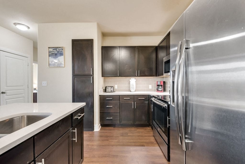 a kitchen with stainless steel appliances and black cabinets