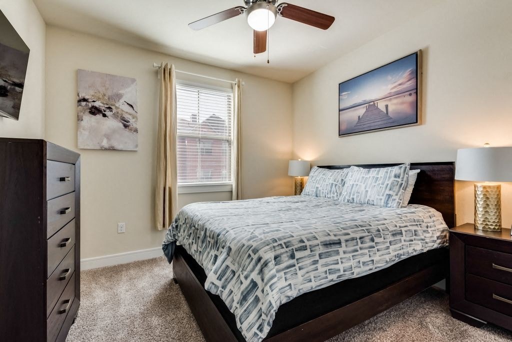 a bedroom with a bed and a ceiling fan