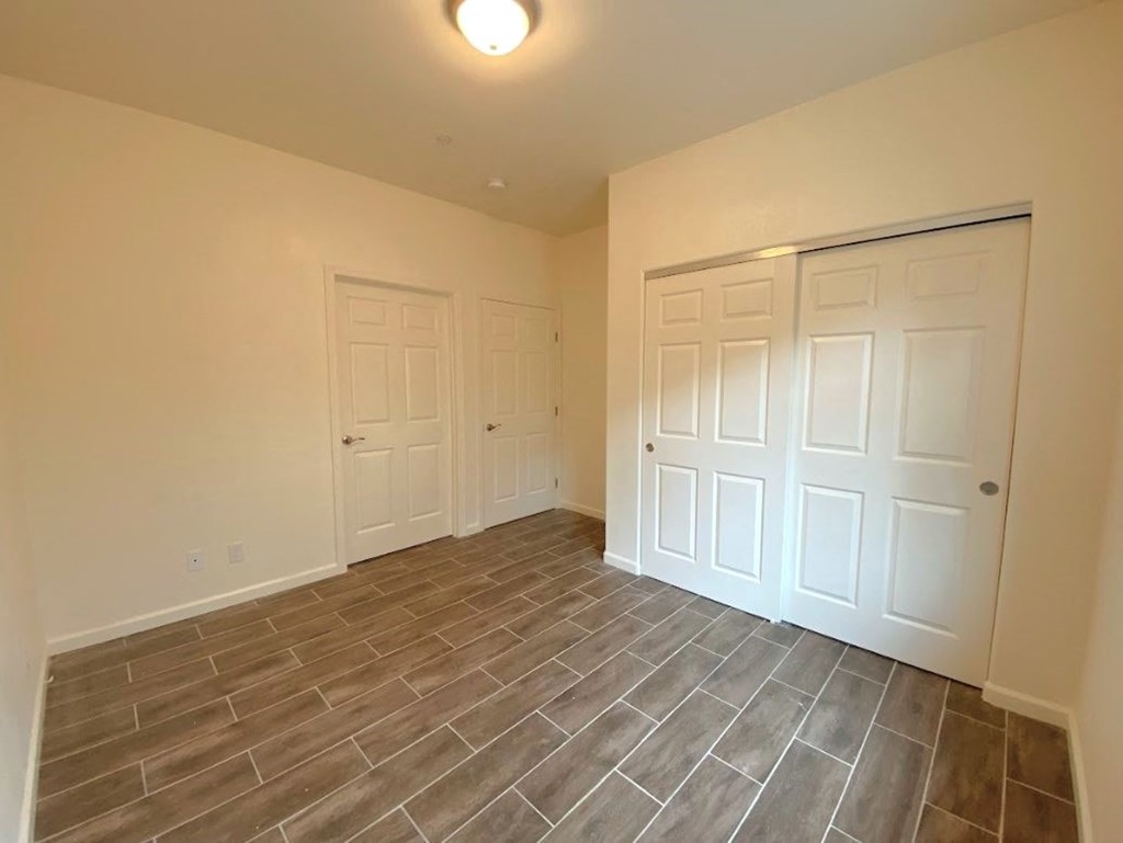 a bedroom with two closets and a tiled floor