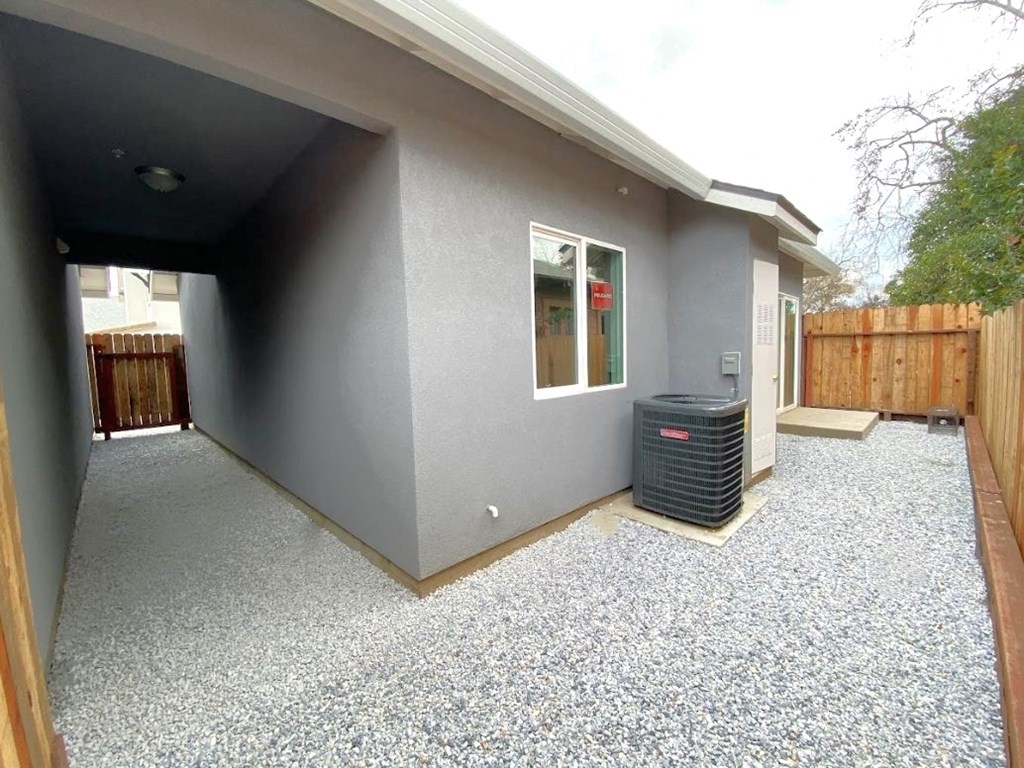 a side view of a house with a driveway and a heater
