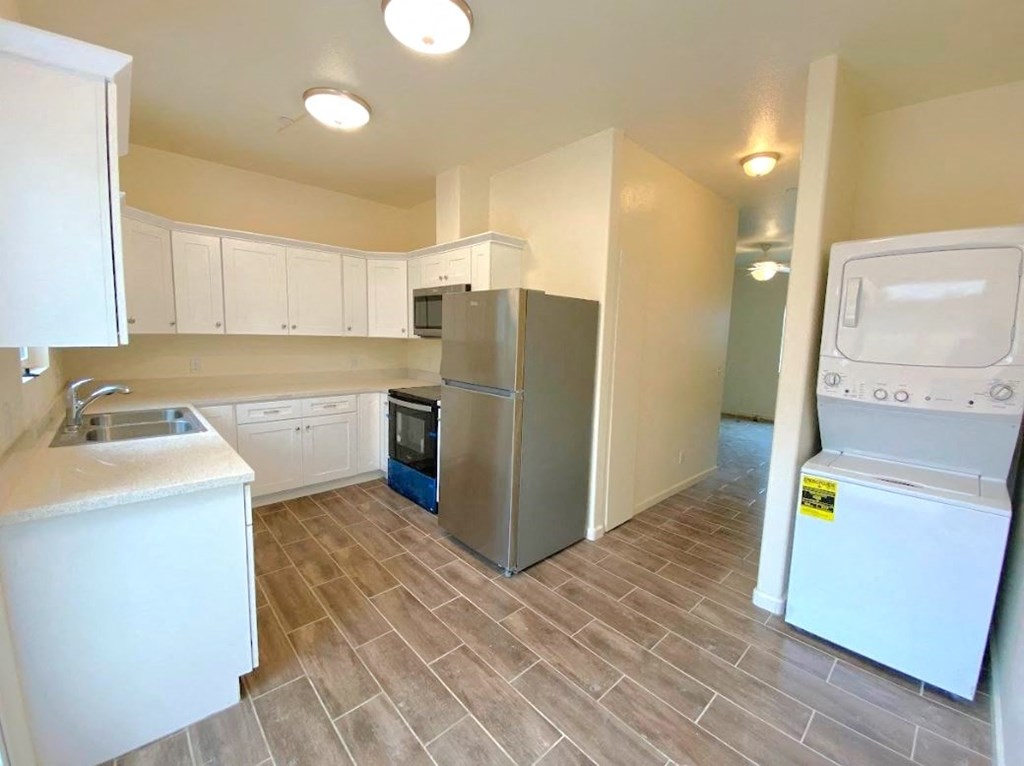 a kitchen with a washing machine and a refrigerator