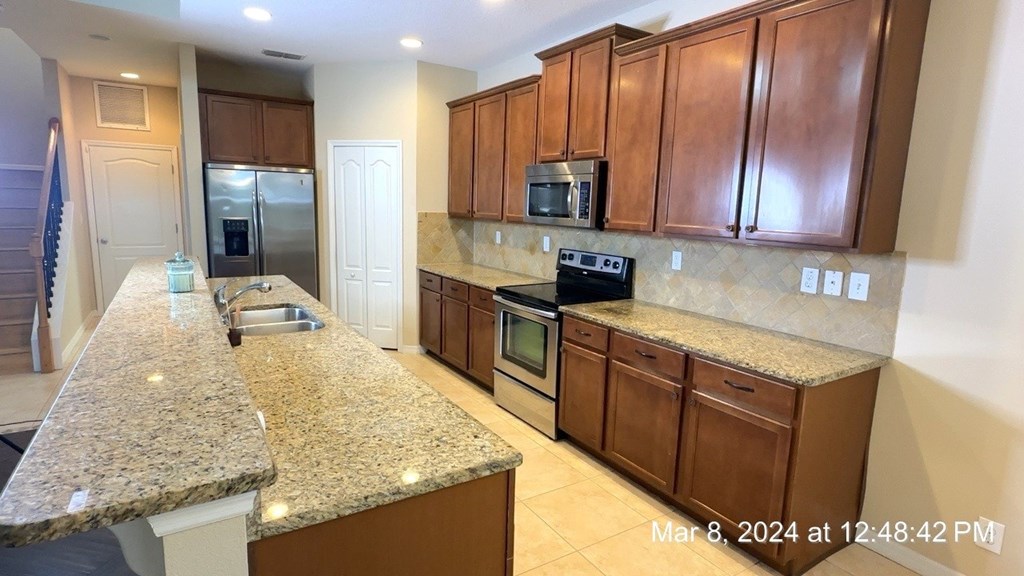 a kitchen with granite counter tops and wooden cabinets
