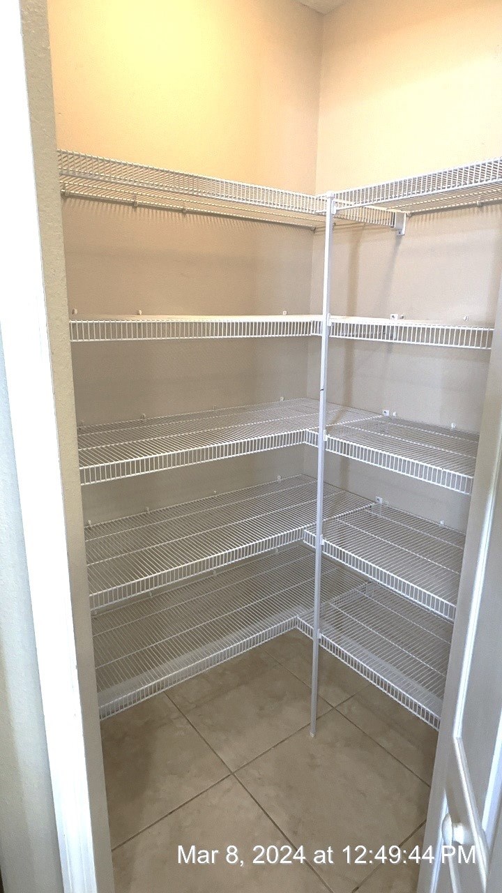 a closet with white shelves and a white door