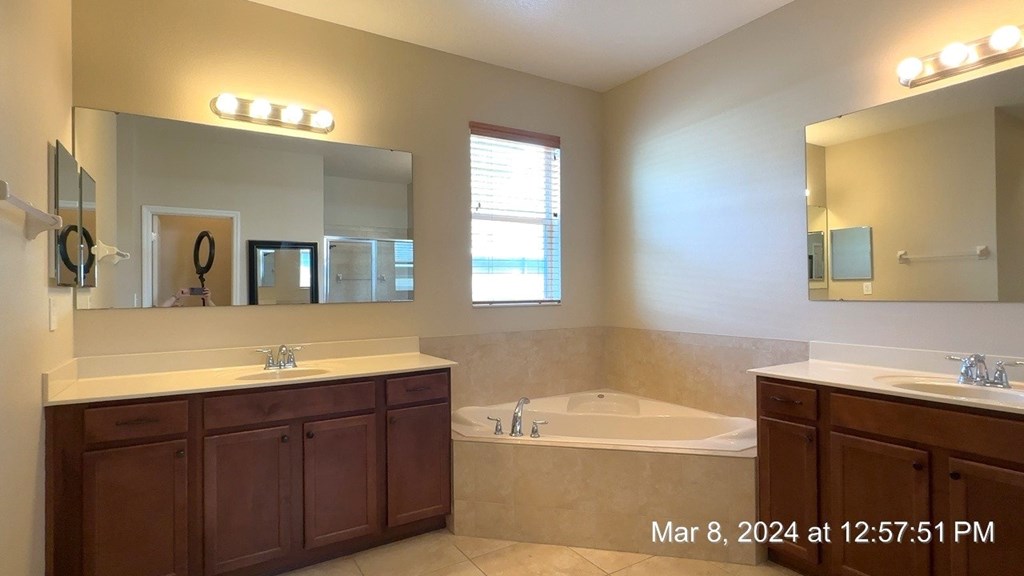 a bathroom with a tub and a sink and a mirror