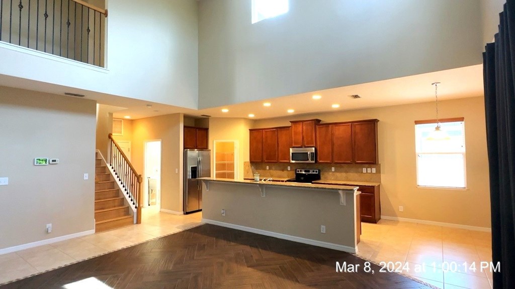 an empty living room with a kitchen and a staircase