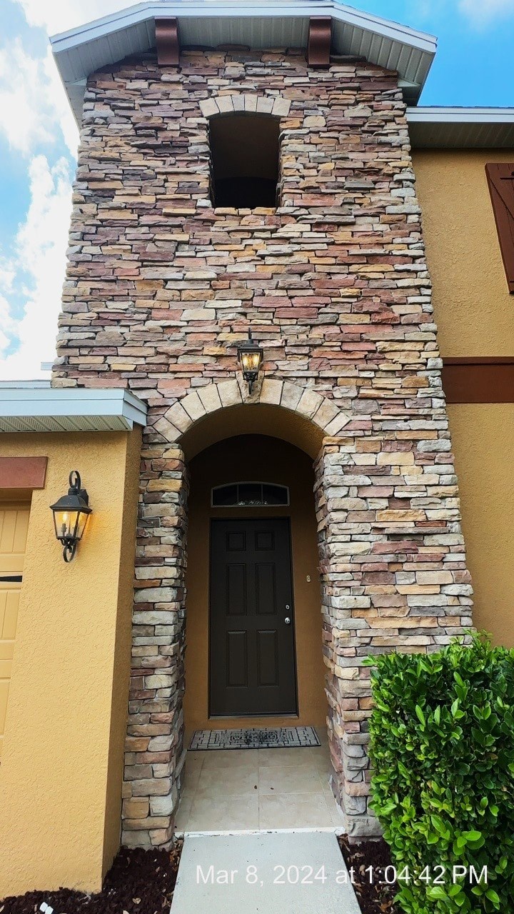 the front door of a house with a stone archway