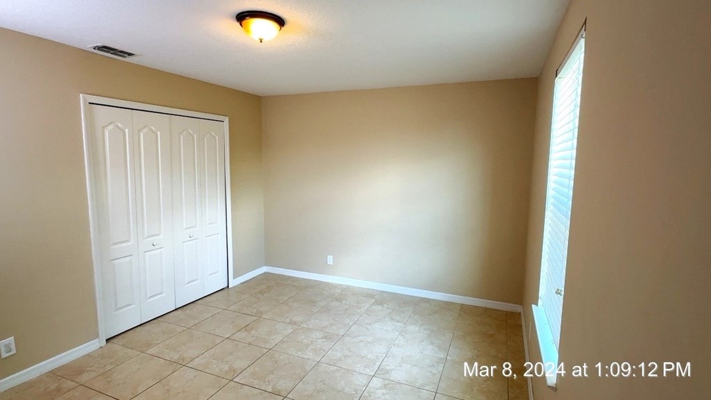 a empty living room with a tile floor and a white door