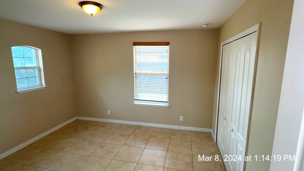 a room with a tiled floor and a white door and window