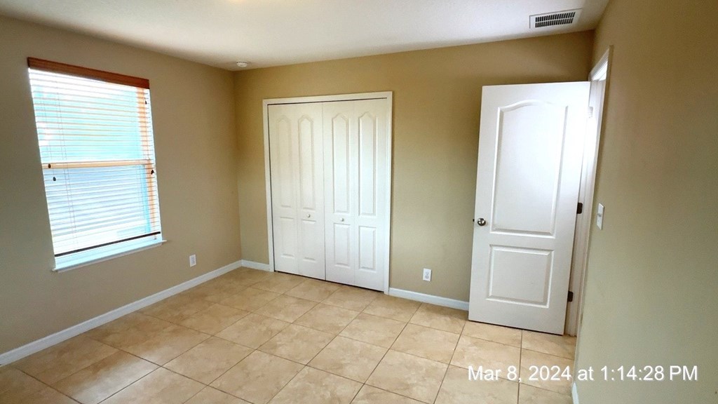 a room with a tiled floor and a door and a window