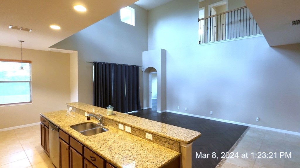 a kitchen with granite counter tops and an empty living room