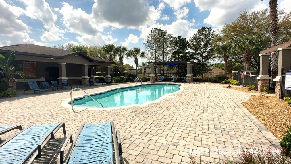 a swimming pool in a backyard with chairs and a house