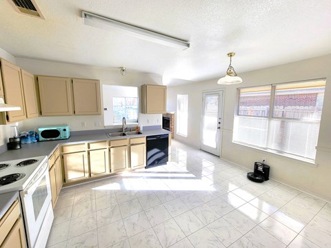 a kitchen with wooden cabinets and a stove and a sink