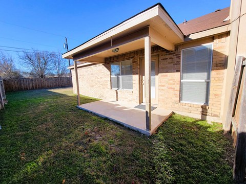 the front porch of a house with a ramp in the grass