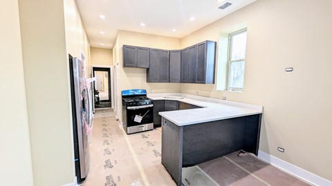 a kitchen with black cabinets and a counter top and a stove