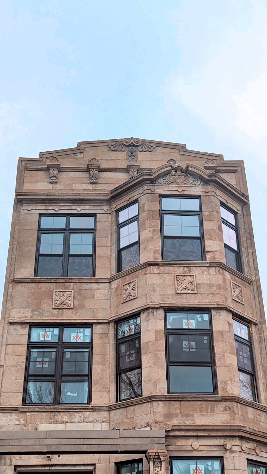 a tall building with many windows and a blue sky