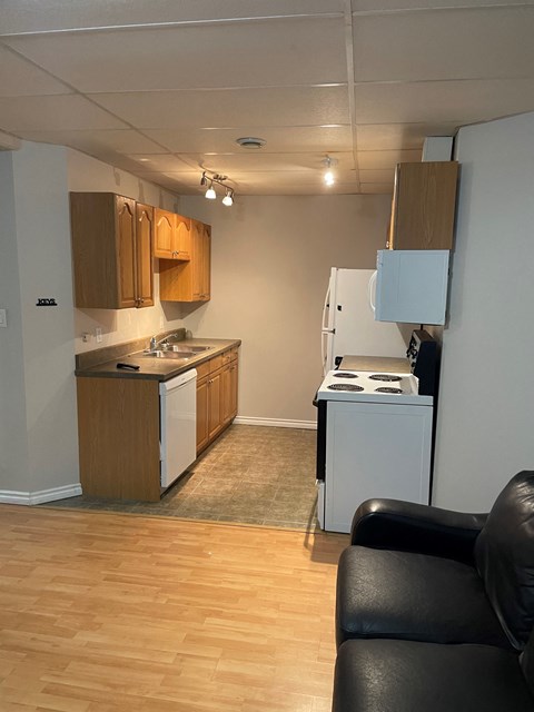 an empty kitchen with a stove refrigerator and sink