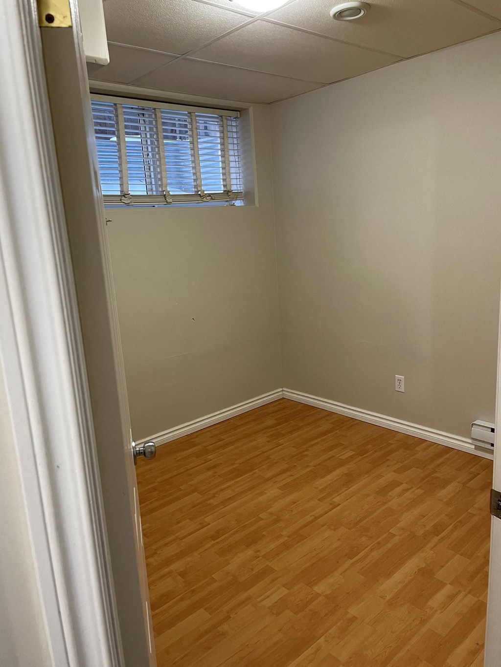 an empty room with wooden floors and a window