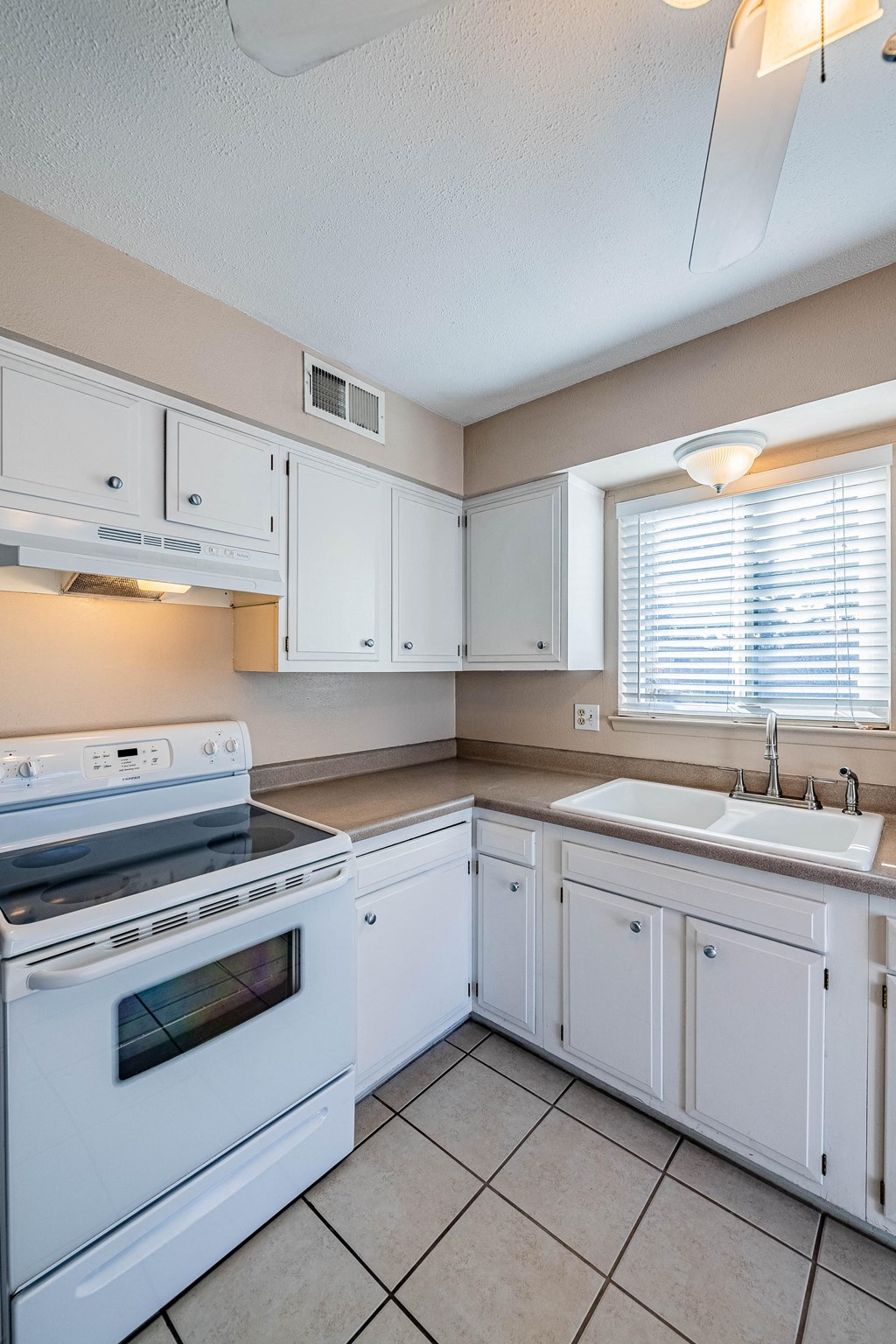 a kitchen with white cabinets and a stove and a sink