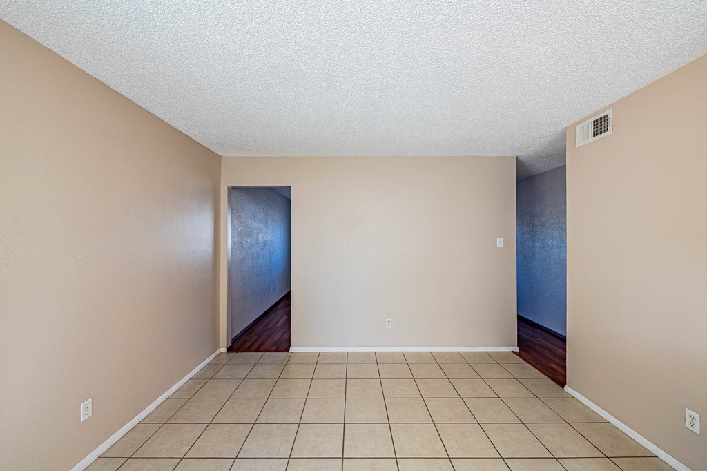 a empty living room with a tiled floor