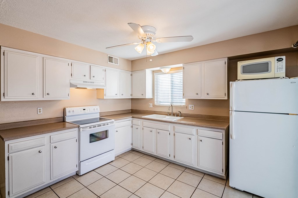 a kitchen with white appliances and white cabinets