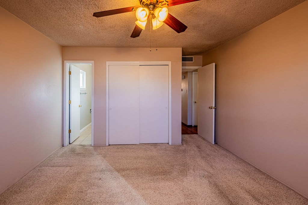 a bedroom with carpeted floors and a ceiling fan