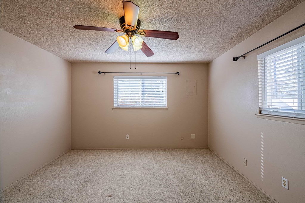 a bedroom with a ceiling fan and a window