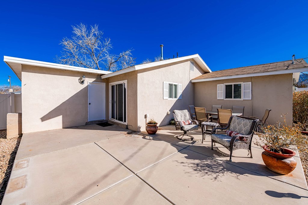 the front yard of a house with a patio and chairs