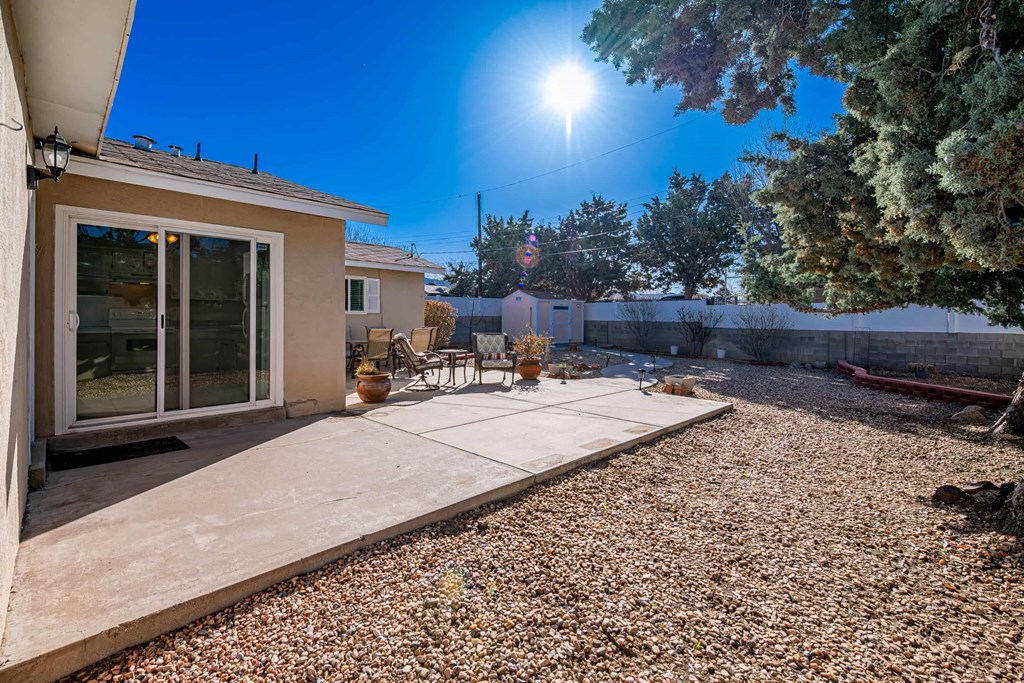 a patio with a table and chairs in front of a house