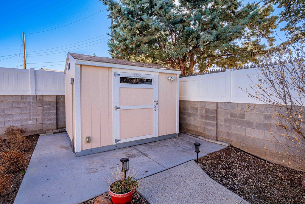 a small shed in a backyard next to a fence