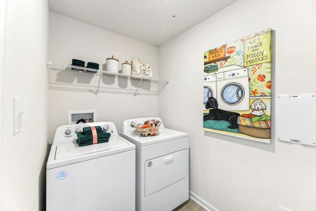 a washer and dryer in a laundry room with a painting on the wall
