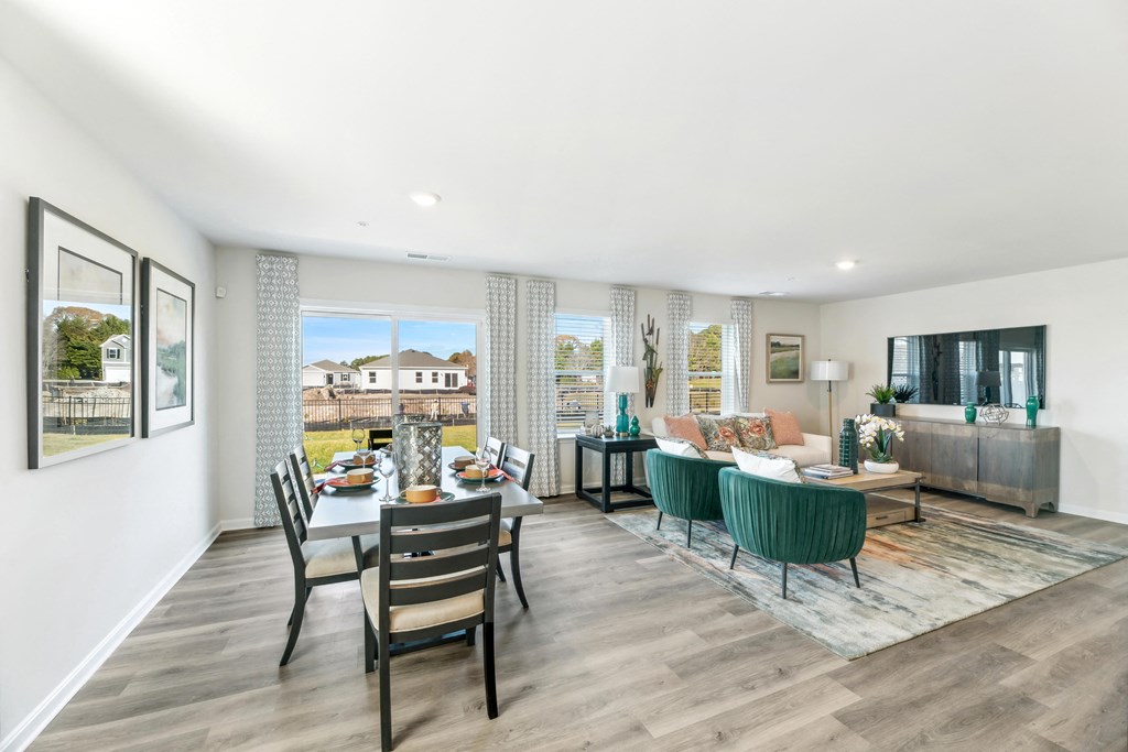 a living room and dining room with a table and chairs
