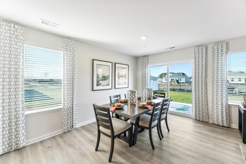 a dining room with a table and chairs and a window