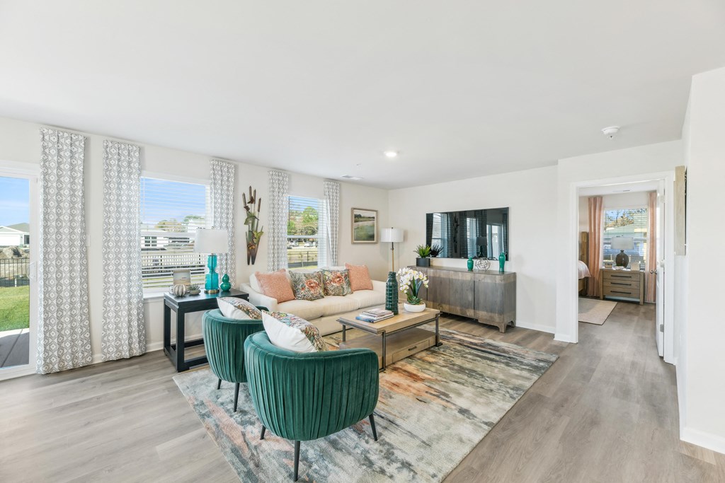 a living room with a couch and chairs and a tv