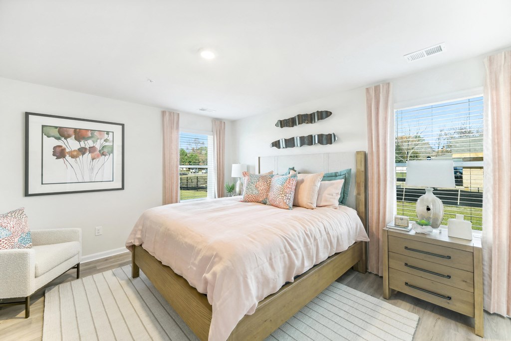 a bedroom with a bed and two windows