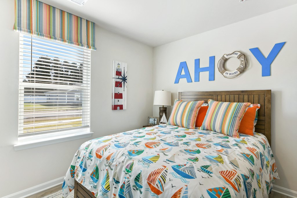 a bedroom with a bed with a colorful comforter   and a window