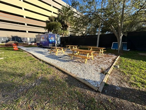 a group of picnic tables in a park next to a building