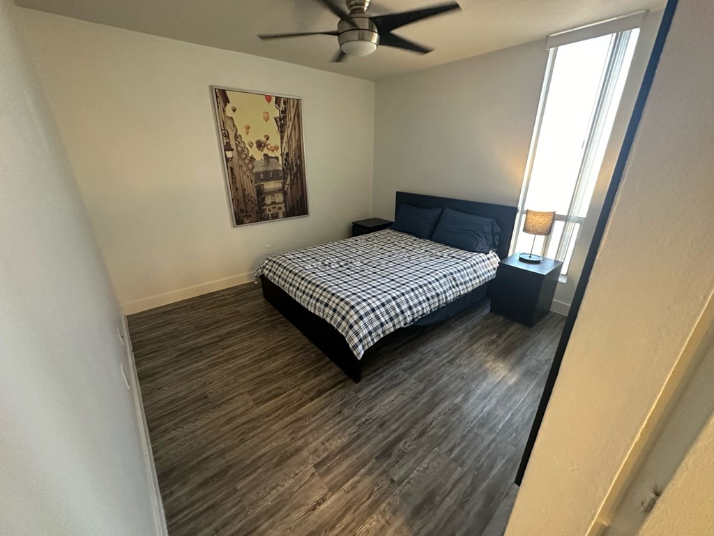 a bedroom with a bed and a ceiling fan