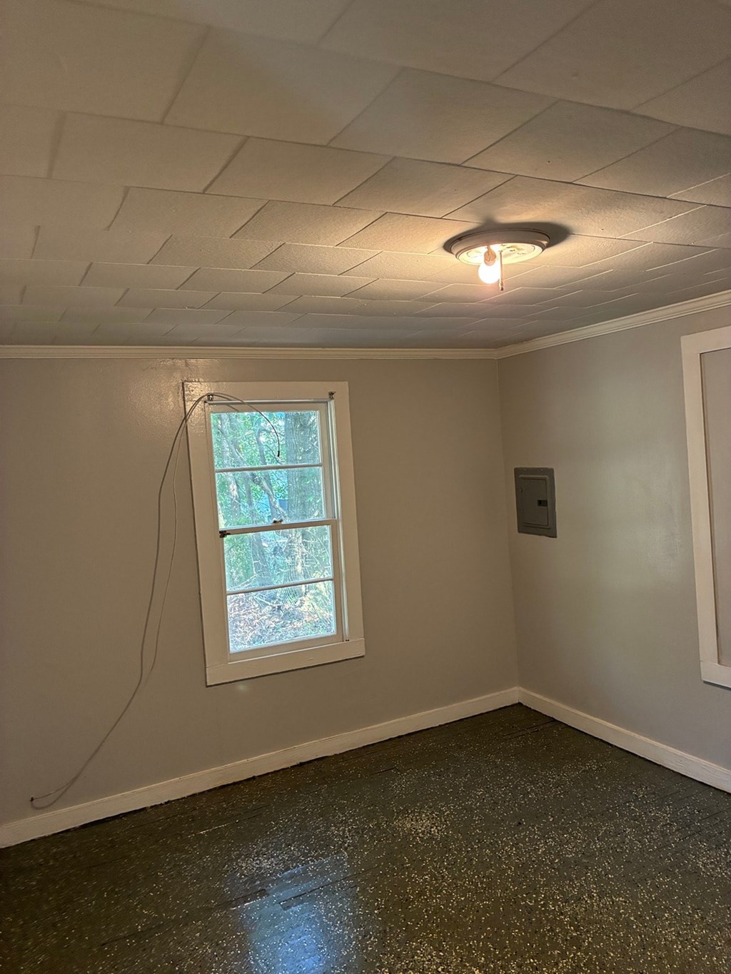 A room with a window and a light on the ceiling.