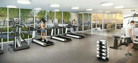 A woman is running on a treadmill in a brightly lit gym.