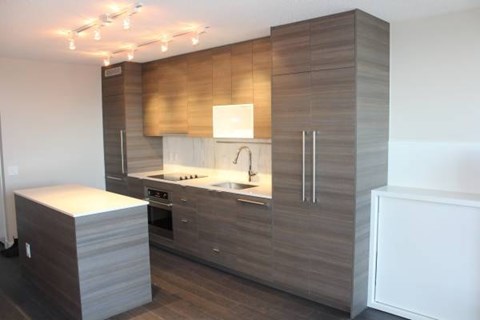 A modern kitchen with a refrigerator, oven, and sink.