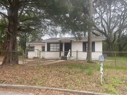 a small house with a fence in front of it