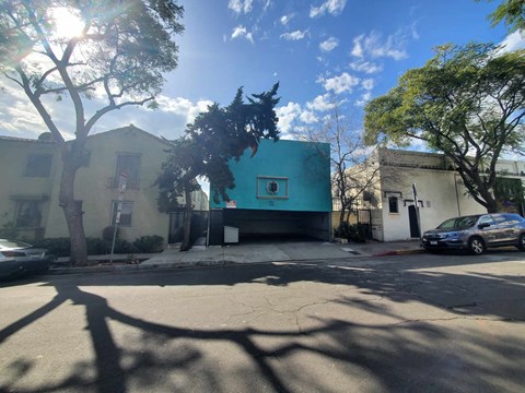 a building with a turquoise facade on a city street