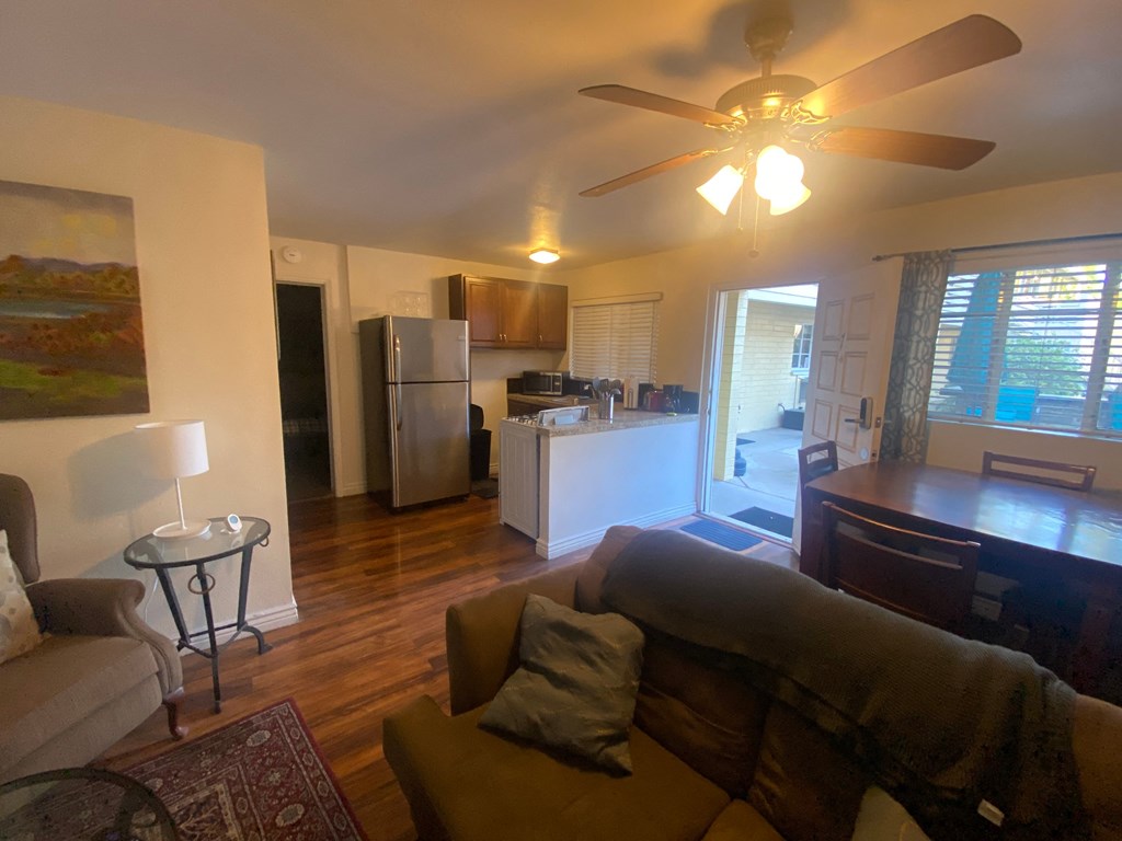 an open living room and kitchen with a ceiling fan