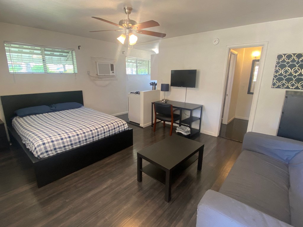 a bedroom with a bed and a living room with a couch and a table