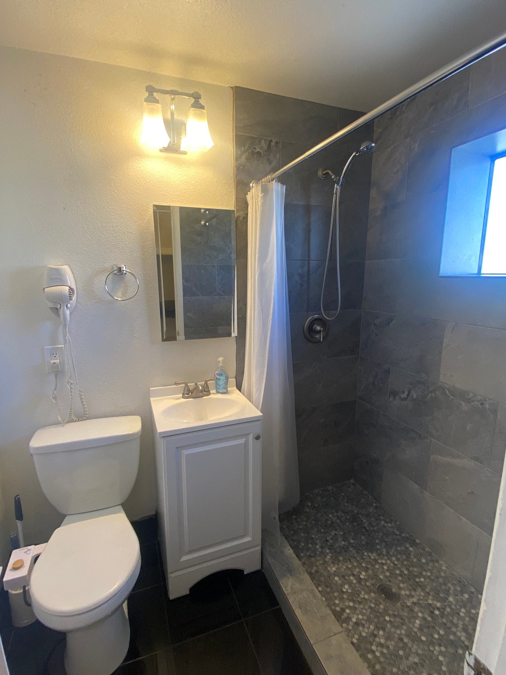 a small bathroom with a shower toilet and sink