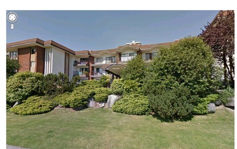 A building with a green lawn in front.