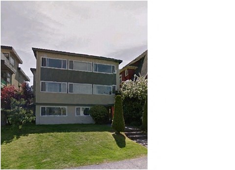 A building with a green lawn in front.