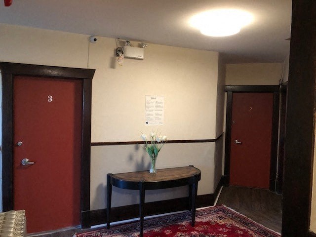 a room with two red doors and a table with flowers