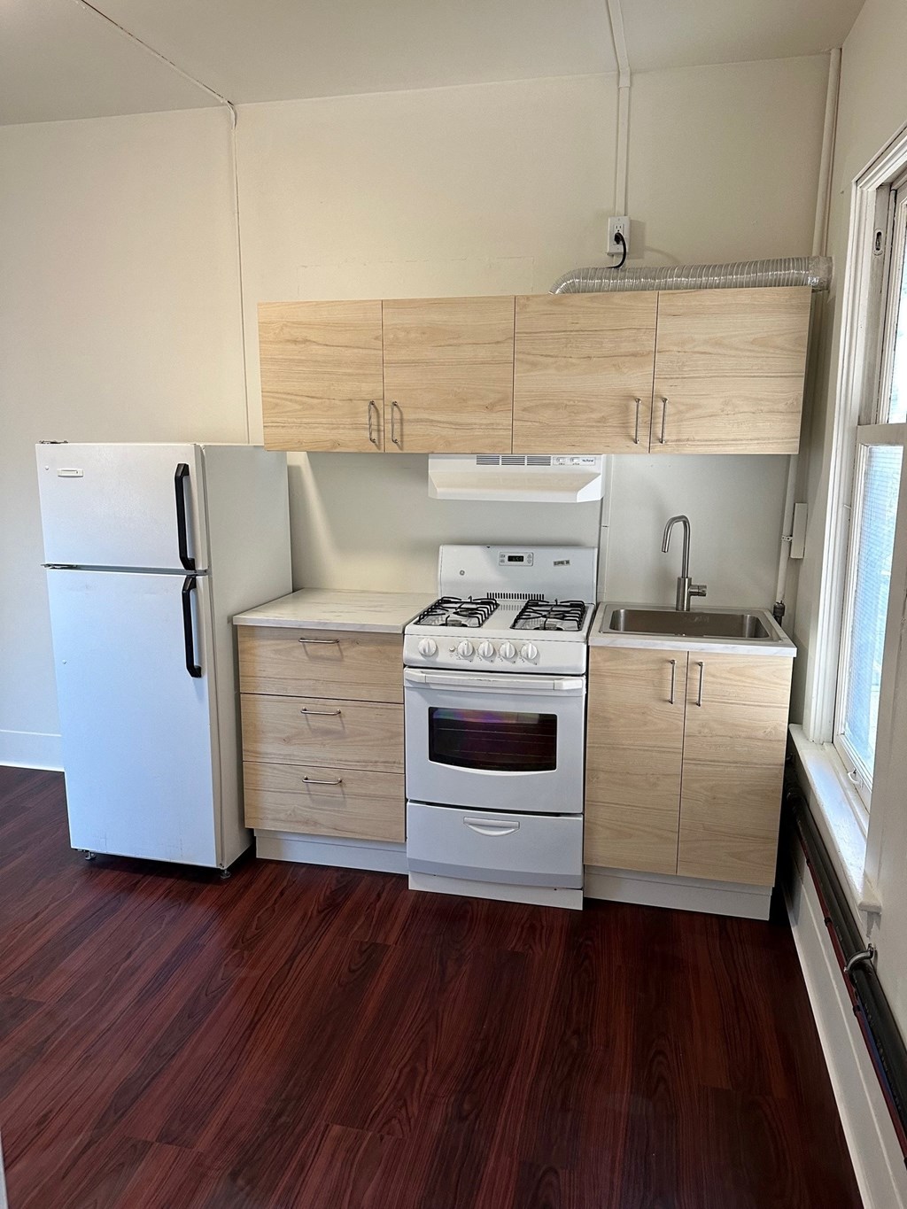 a small kitchen with a stove refrigerator and sink