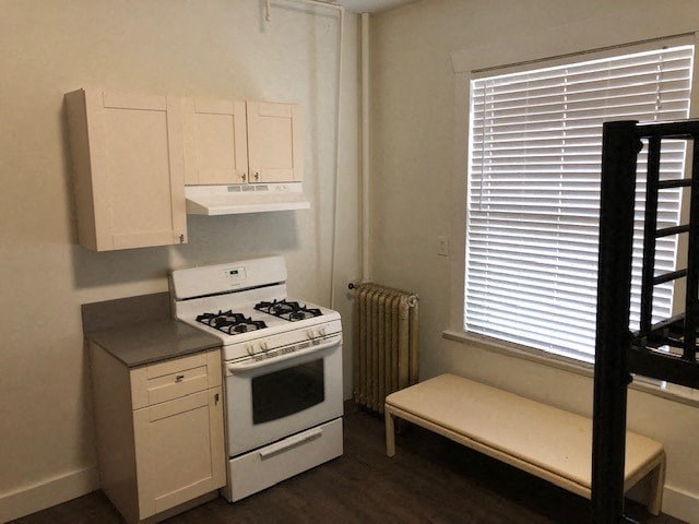 a small kitchen with a stove and a window